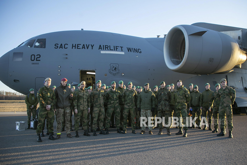  Dalam foto yang disediakan oleh Kementerian Pertahanan Nasional Lituania ini, tentara Norwegia dari batalyon NATO berpose di depan pesawat militer saat mereka tiba di bandara di Kaunas, Lituania, Ahad, 27 Februari 2022. Norwegia mengerahkan kemampuan militer tambahan di Lituania untuk memperkuat pasukan depan NATO di Lituania.