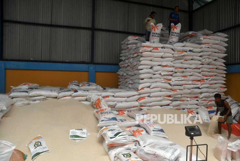 Pekerja memasukkan beras ke dalam karung di gudang Bulog Dramaga, Kabupaten Bogor, Jawa Barat, Selasa (27/2/2024). 