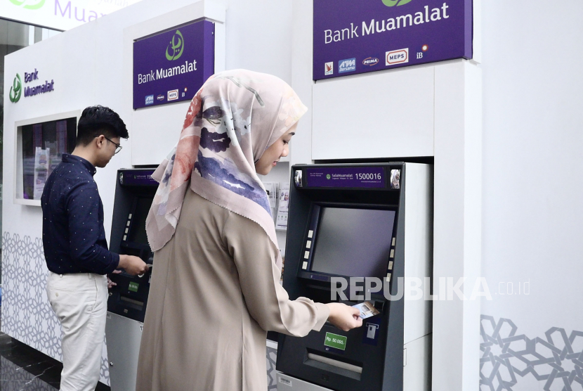Karyawan bertransaksi menggunakan kartu Shar-E Debit Muamalat di mesin ATM Muamalat Tower, Jakarta, Rabu (31/5/2023). Bank Muamalat memberikan kemudahan bagi jamaah haji yang ingin bertransaksi di tanah suci melalui fasilitas kartu Shar-E Debit Muamalat. Kartu Shar-E Debit Muamalat berlogo VISA ini dapat digunakan di mesin ATM berlogo VISA/Plus di Arab Saudi dan di mesin ATM milik Bank Al Rajhi yang tersebar di Makkah, Madinah dan Jeddah. Kelebihan dari kartu Shar-E Debit Muamalat ini adalah tersedia pilihan transaksi bahasa Indonesia saat bertransaksi di ATM.