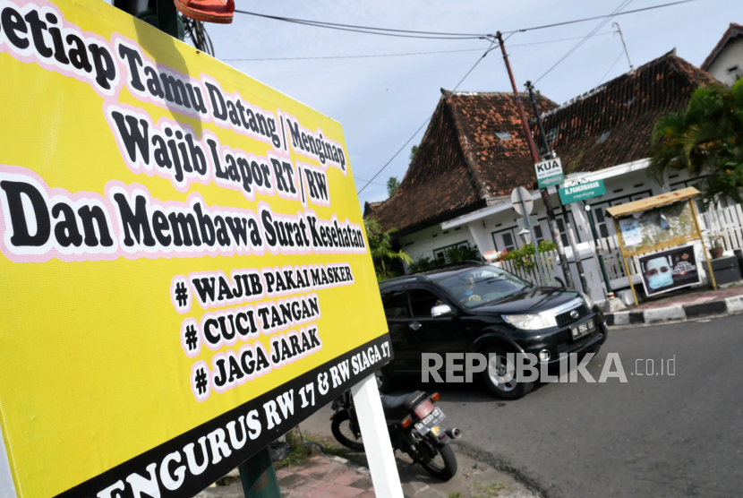 Spanduk imbauan aturan protokol kesehatan Covid-19 dan pendatang terpasang di pintu masuk kampung di Yogyakarta. 