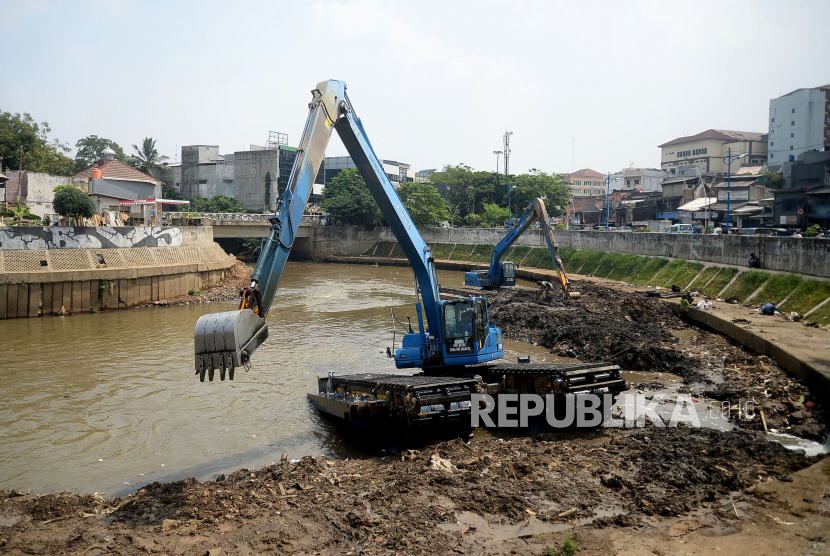 Pekerja dengan alat berat mengeruk endapan sampah bercampur lumpur di Sungai Ciliwung kawasan Jatinegara Barat, Jakarta, Kamis (23/7). Pengerukan tersebut untuk menormalkan kedalaman sungai sehingga aliran air semakin lancar. 