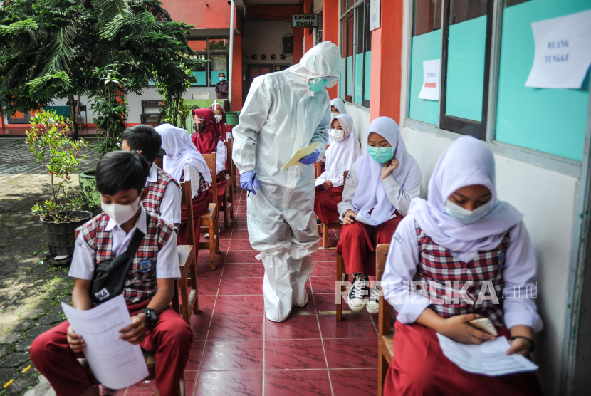 Petugas kesehatan memberikan nomor urut kepada siswa untuk mengikuti tes pcr secara acak di SDN 025 Cikutra, Bandung, Jawa Barat, Jumat (22/10/2021). Dinas Kesehatan Kota Bandung mencatat, hingga Kamis (21/10/2021) sebanyak 54 pelajar dan guru di berbagai sekolah di Kota Bandung dinyatakan positif COVID-19 hasil dari tes usap PCR secara acak yang dilakukan sejak 15 oktober hingga 19 Oktober 2021. 