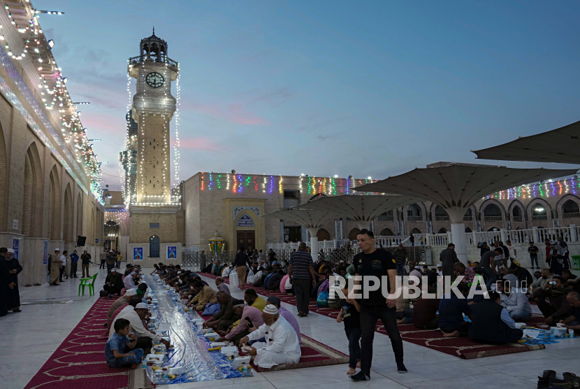 Umat Muslim berkumpul untuk makan berbuka puasa umum gratis selama hari pertama Ramadhan di masjid syekh Abdul qader Gilani di Baghdad, Irak, Sabtu, 2 April 2022. Muslim Sunni dan Syiah Irak Beda Hari Rayakan Idul Adha
