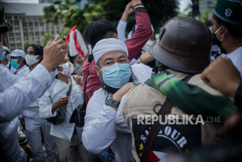 Aparat kepolisian membubarkan paksa massa aksi  unjuk rasa 1812 Front Pembela Islam (FPI) yang hendak menggelar aksi di sekitar Patung Kuda Arjuna Wiwaha, Jakarta Pusat, Jumat (18/12). Polisi memukul mundur massa yang menolak dibubarkan guna menghindari kerumunan. Sebanyak 5.000 personel gabungan dari unsur TNI-Polri dan Pemprov DKI Jakarta disiapkan untuk mengawal dan mengamankan unjuk rasa 1812 di kawasan Istana Negara. Republika/Thoudy Badai