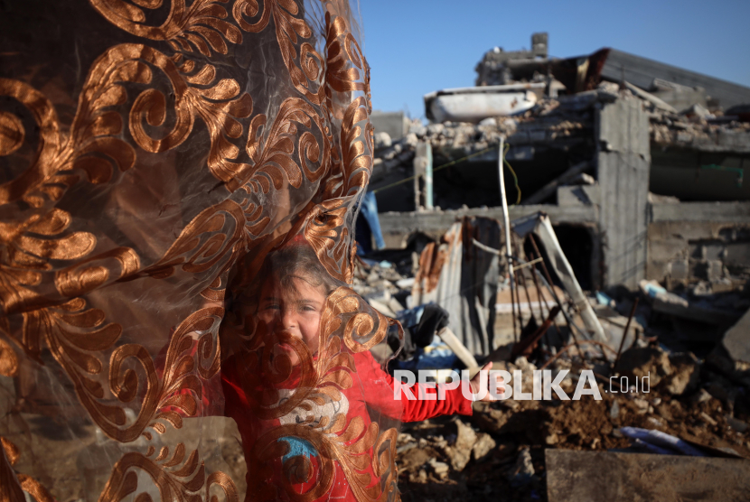 Seorang anak Palestina berdiri di depan rumahnya yang hancur di lingkungan Al-Zaytoun di Kota Gaza, Palestina, Jumat (14/2/2025). Warga Palestina melanjutkan kehidupan sehari-hari mereka dalam kondisi yang sulit. Lebih dari 90 persen rumah dan 88 persen sekolah rusak atau hancur, belum lagi pemboman jalan, rumah sakit, peternakan dan fasilitas pengolahan air. Laporan UNDP yang dirilis tahun lalu mengatakan bahwa rekonstruksi Gaza mungkin memerlukan waktu setidaknya hingga tahun 2040.