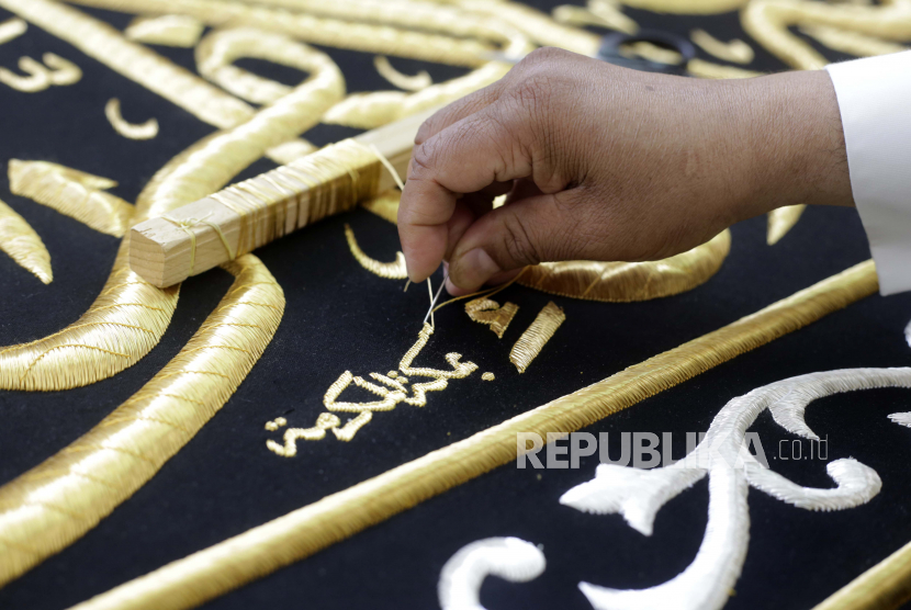 Seorang pria Saudi menyulam kaligrafi Islam, baik menggunakan benang perak murni atau benang perak berlapis emas, selama tahap akhir dalam persiapan tirai, atau Kiswah, yang menutupi Ka