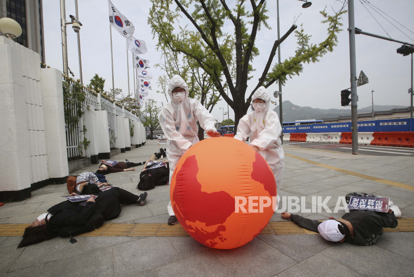 Aktivis lingkungan dengan balon bumi melakukan aksi mati-matian dalam unjuk rasa memperingati Hari Bumi melawan perubahan iklim.