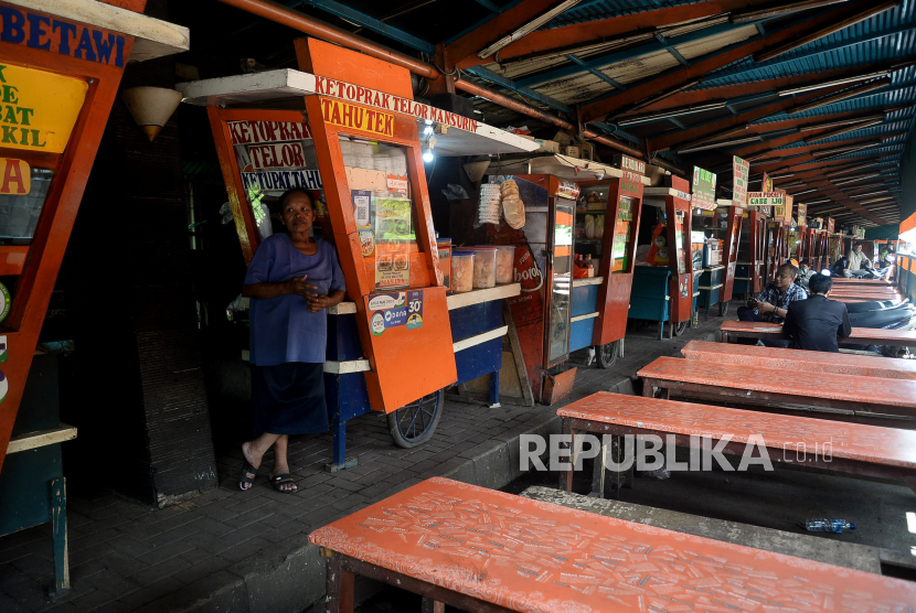 Pedagang makanan menanti pembeli di Pusat Jajanan Tenda Hijau, Karet, Jakarta. Di masa PSBB seperti saat ini bayak restoran yang merumahkan karyawan karena waktur operasional yang pendek dan sepinya pembeli, 