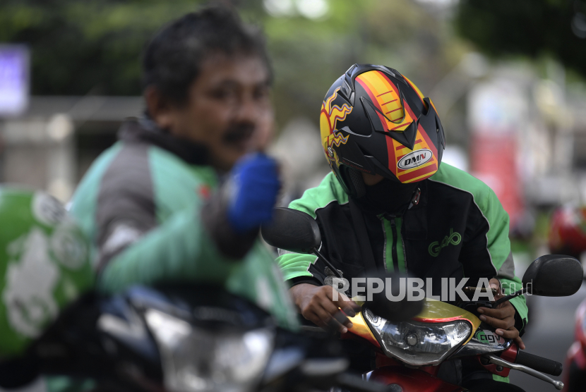 Pengemudi ojek daring menunggu orderan di kawasan Tanah Kusir, Jakarta, Jumat (7/4). Kementerian Perhubungan menerbitkan Peraturan Menteri Perhubungan (Permenhub) Nomor 18 Tahun 2020 tentang Pengendalian Transportasi Dalam Rangka Pencegahan Penyebaran Covid-19. 