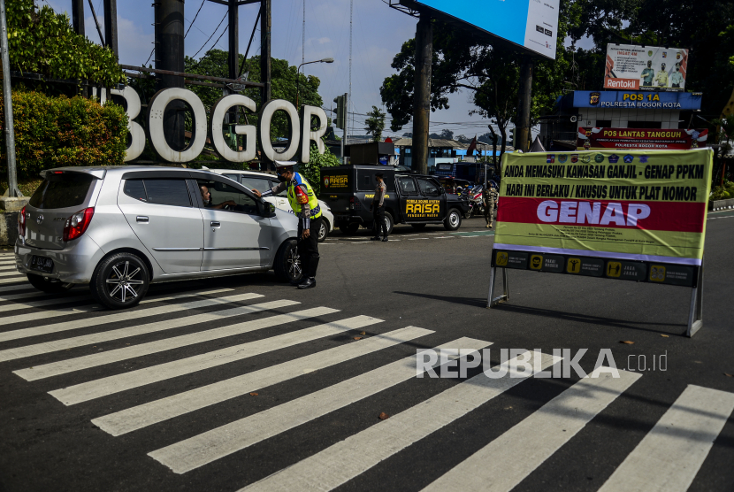 Polisi menghentikan kendaraan saat pemberlakuan aturan ganjil genap di Jalan Pajajaran, Kota Bogor, Jawa Barat, Ahad (20/6). Pemerintah Kota Bogor kembali memberlakukan aturan ganjil genap untuk kendaraan roda dua dan empat pada setiap akhir pekan untuk mengurangi mobilitas warga sekaligus mengendalikan lonjakan kasus positif Covid-19 di Kota Bogor. Republika/Putra M. Akbar