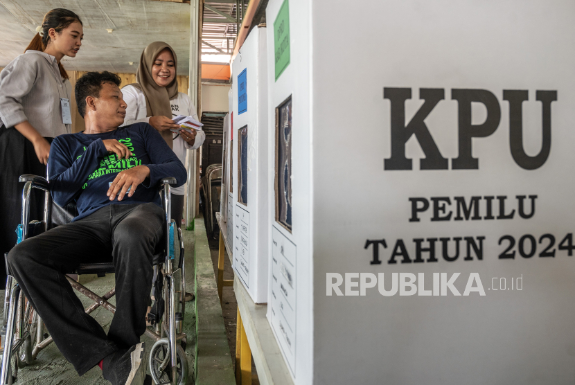 Seorang penyandang disabilitas dibantu pendampingnya memasukkan surat suara ke kotak suara pada simulasi pemungutan suara di TPS di Kantor Komisi Pemilihan Umum (KPU) Kabupaten Sigi, Sulawesi Tengah, Kamis (8/2/2024). KPU memberi layanan khusus bagi pemilih penyandang disabilitas yang jumlahnya mencapai 0,5 persen atau 1.101.178 dari 204,8 juta yang terdaftar sebagai pemilih tetap Pemilu 2024 seperti TPS yang dekat dan mudah diakses, tidak bertangga, tidak berbatu, tidak berumput tebal, tidak berparit, pintu masuk minimal 90 cm, template surat suara bagi tuna netra serta dapat didampingi. 