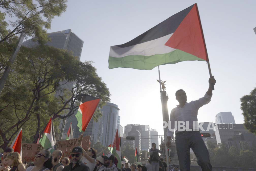 Pria mengibarkan bendera Palestina saat unjuk rasa menentang perang terbaru Israel-Hamas dan mendukung rakyat Palestina di Gaza, di Mexico City, Minggu, 5 November 2023.