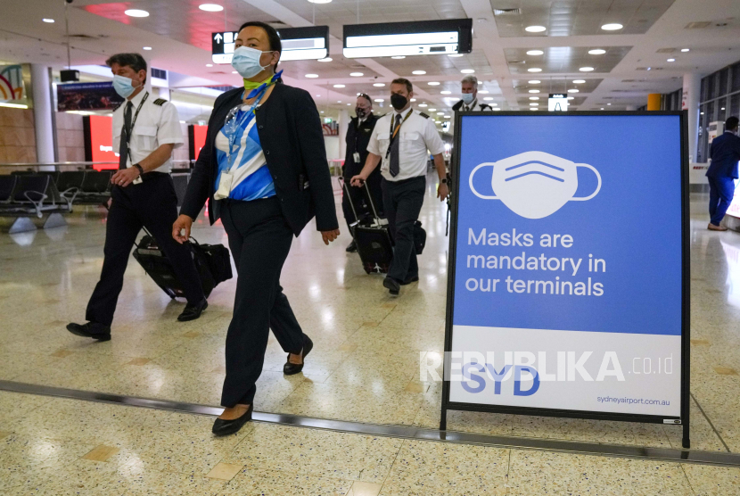  Seorang awak pesawat berjalan melalui terminal di Bandara Sydney, Senin, 29 November 2021. Pihak berwenang di Australia mengatakan Minggu, 28 November 2021, bahwa dua pelancong yang tiba di Sydney dari Afrika menjadi yang pertama di negara itu untuk dinyatakan positif varian baru dari coronavirus, omicron.