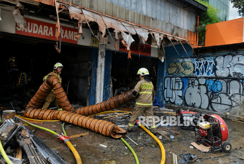 Petugas Penanggulangan Kebakaran dan Penyelamatan (Gulkarmat) DKI Jakarta melakukan pendinginan sisa kebakaran di Jalan Mampang Prapatan, Jakarta Selatan, Jumat (19/4/2024). Kebakaran yang menghanguskan toko bingkai tersebut terjadi pada Kamis (18/4) kemarin, sekitar pukul 19.30 WIB yang menewaskan sebanyak tujuh orang dan lima orang mengalami luka-luka. Ketujuh korban tersebut ditemukan tewas di lantai 2 saat petugas melakukan pendingina.