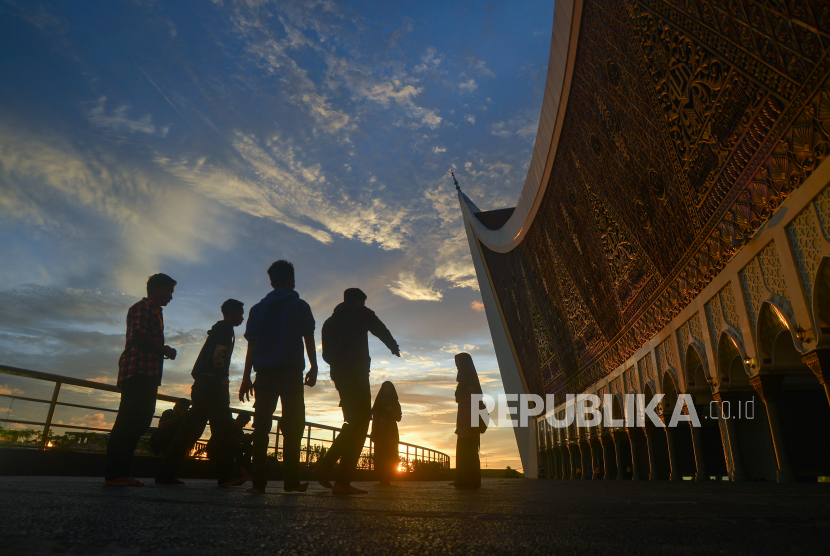 Sejumlah pengunjung berdiri di halaman Masjid Raya Sumatera Barat (Sumbar), di Padang, Rabu (13/4/2022). Asita mencatat jumlah wisatawan ke Sumbar saat libur lebaran naik hingga 200 persen.