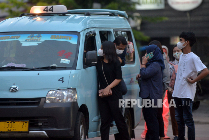 Penumpang turun dari angkutan umum JakLingko dengan memakai masker di Jakarta, Selasa (3/1/2023). 