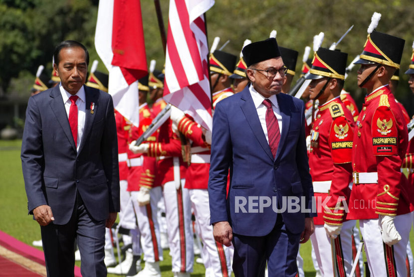 Perdana Menteri Malaysia Anwar Ibrahim (kanan) memeriksa pasukan kehormatan dengan Presiden Joko Widodo pada pertemuan mereka di istana kepresidenan di Bogor, Jawa Barat, Senin (9/1/2023).