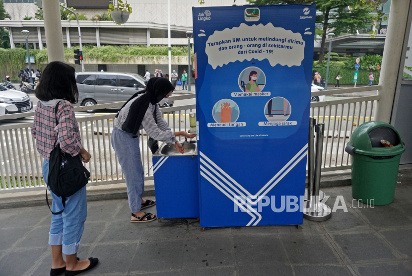 Sejumlah penumpang mencuci tangan sebelum menaiki bus TransJakarta di halte Bundaran Hotel Indonesia,Jakarta, Kamis (30/12). Dinas Kesehatan DKI Jakarta menginginkan agar adaptasi kebiasaan baru dan protokol kesehatan (prokes) khususnya di angkutan umum tetap berkelanjutan untuk mengantisipasi ancaman penularan dari varian baru Covid-19 seperti omicron. Prayogi/Republika
