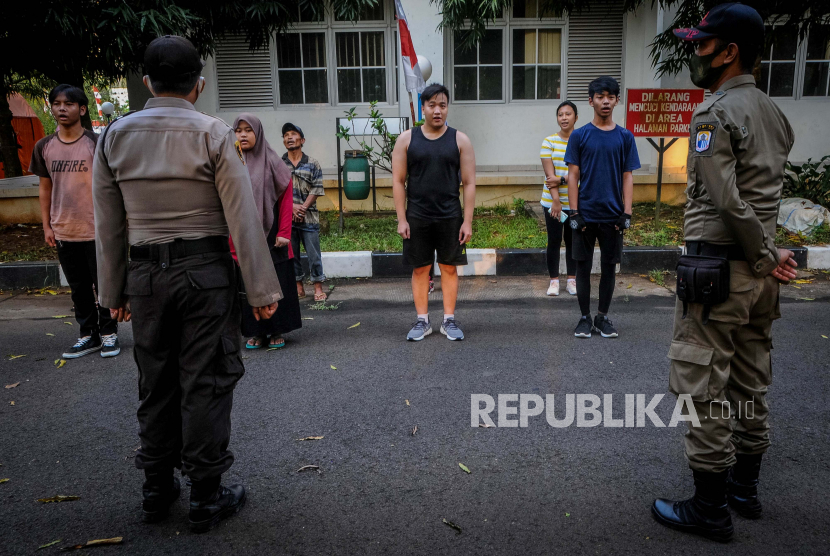 Warga menyanyikan lagu Indonesia Raya saat razia penggunaan masker di Alun-alun Rangkasbitung, Lebak, Banten, Sabtu (15/8/2020). Razia yang dilakukan oleh petugas gabungan tersebut guna mengedukasi masyarakat tentang pentingnya penggunaan masker dalam rangka penerapan protokol kesehatan untuk memutus mata rantai penyebaran COVID-19. ANTARA FOTO/Muhammad Bagus Khoirunas/agr/pras.