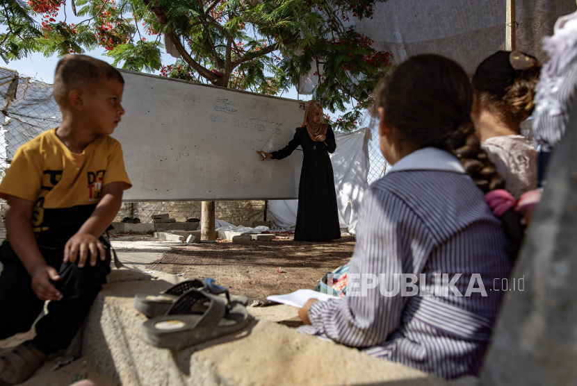 Palestinian students attend a class in a tent school in the Khan Yunis refugee camp in the southern Gaza Strip, 13 June 2024. After the Israeli army destroyed schools in southern Gaza, they established a group of Palestinian teachers, a 