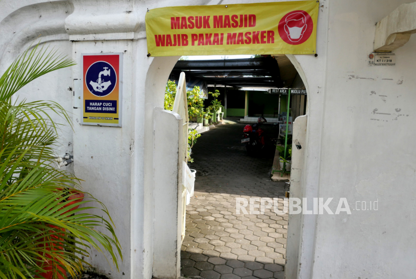Spanduk imbauan aturan protokol kesehatan Covid-19 terpasang di pintu masjid, Yogyakarta, Ahad (21/2). 