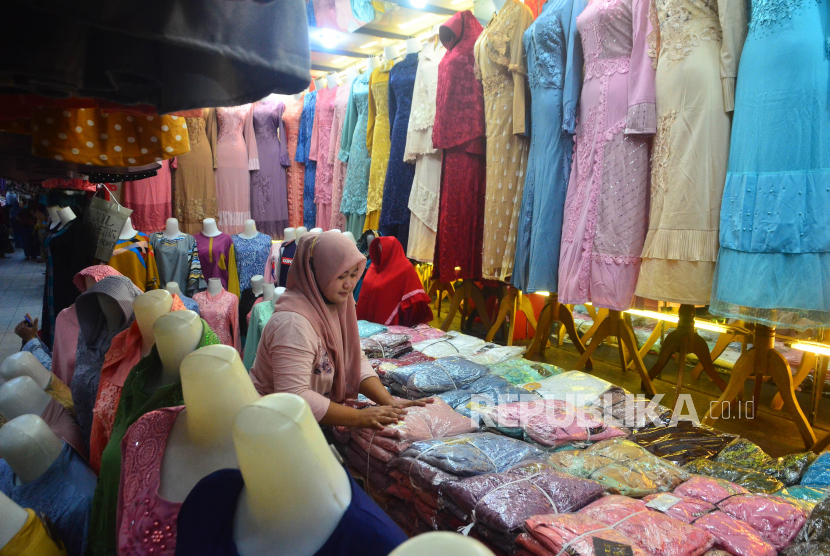 Pedagang merapikan busana muslim dagangannya di Pasar Kliwon, Kudus, Jawa Tengah, Senin (26/4/2021). 