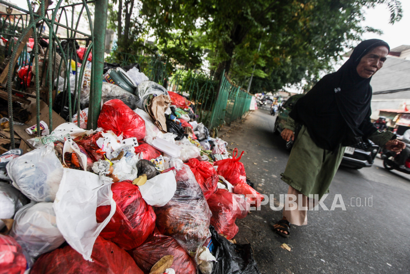 Residents walk near a pile of rubbish on Jalan Proklik, Sukmajaya, Depok City, West Java, Thursday (16/5/2024). 