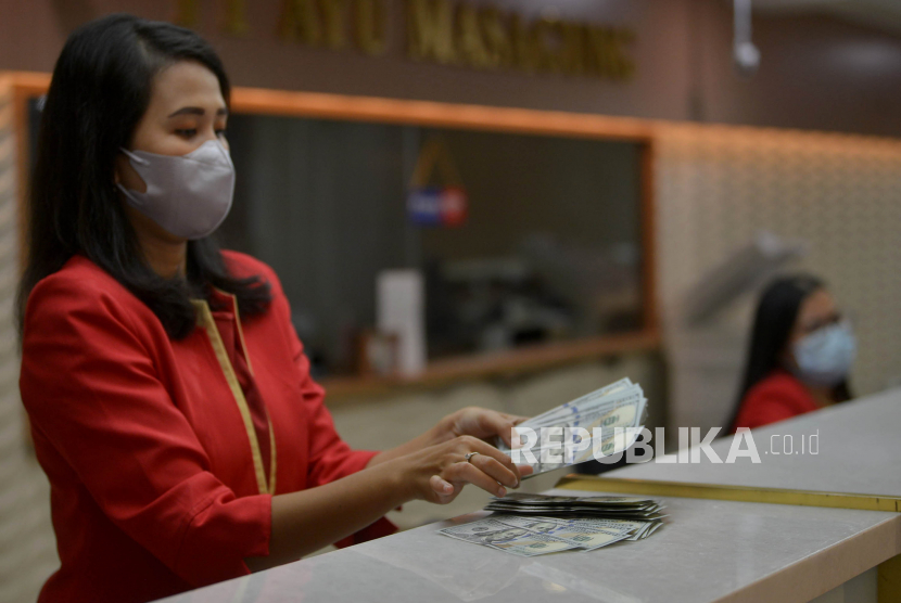 Petugas menghitung uang dolar AS di salah satu gerai penukaran mata uang asing di Jakarta, Kamis (29/9/2022). 