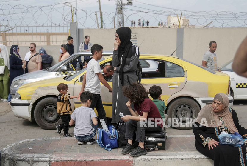 Warga Palestina dengan kewarganegaraan ganda menunggu untuk melintasi perbatasan Rafah dengan Mesir, Jalur Gaza selatan. 
