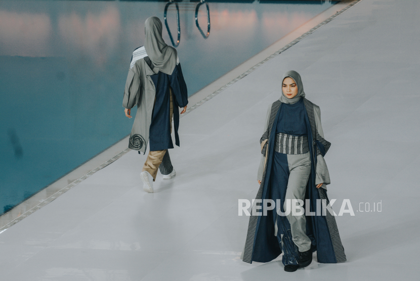 Model mengenakan busana rancangan mahasiswa Institut Kesenian Jakarta dalam Embracing Jakarta Muslim Fashion Week (JMFW) 2021 di Aquatic Gelora Bung Karno (GBK), Jakarta, Kamis (18/11).