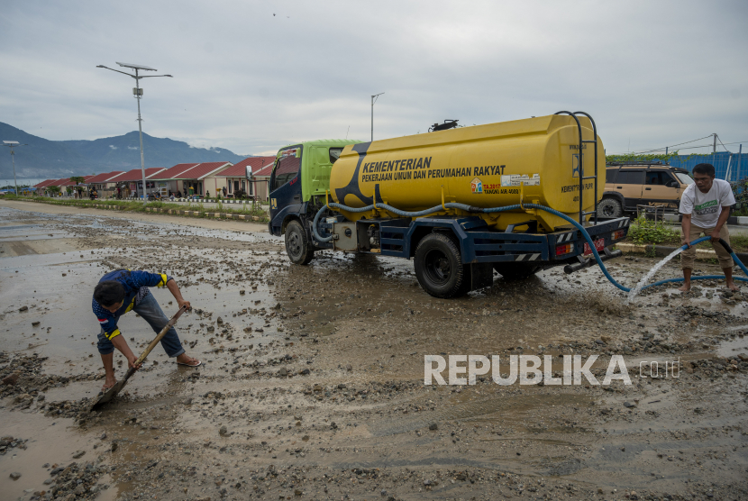 Petugas membersihkan sisa material yang terbawa banjir. BPBD Banggai telah membuat dapur umum di lapangan bola untuk korban banjir. Ilustrasi.