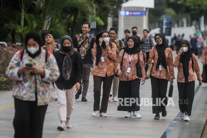Pekerja berjalan saat jam pulang kerja di kawasan Sudirman, Jakarta, Selasa (21/11/2023). 