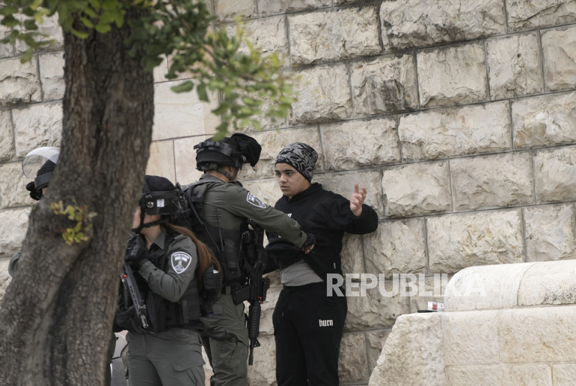 Seorang petugas Polisi Perbatasan Israel menggeledah seorang remaja Palestina di luar kompleks Masjid Al-Aqsa di Kota Tua Yerusalem menjelang salat Jumat, Jumat, (23/2/2024).