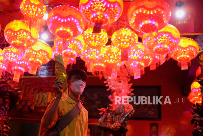 Warga etnis Tionghoa membawa uang kertas yang telah dibakar saat pelaksanaan sembahyang perayaan malam Imlek di Vihara Amurva Bhumi, Jakarta, Sabtu (21/1/2023) malam. Pelaksanaan sembahyang malam tersebut dilaksanakan dalam rangka pergantian Tahun Baru Imlek 2574 menyambut tahun kelinci air.