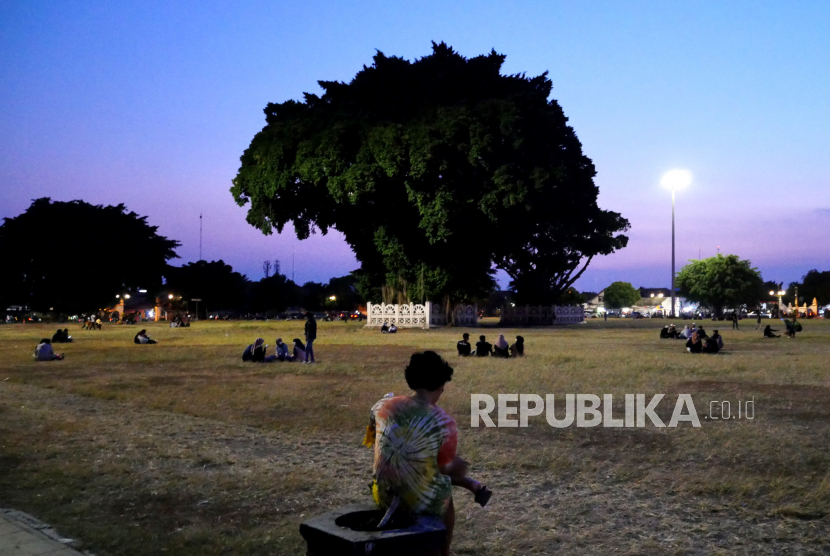 Warga menghabiskan waktu saat senja di Alun-alun Selatan Yogyakarta.