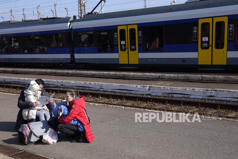 Pengungsi yang melarikan diri dari Ukraina dari perang menunggu untuk meninggalkan stasiun kereta api di Zahony, Hongaria, Ahad, 6 Maret 2022.