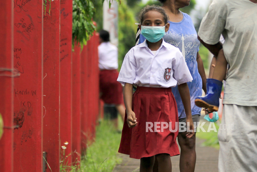 Seorang siswa SD dengan masker di wajahnya berjalan meninggalkan sekolah usai melakukan pendaftaran ulang pada hari pertama sekolah di Jayapura, Papua, Senin (13/7/2020). (ilustrasi)