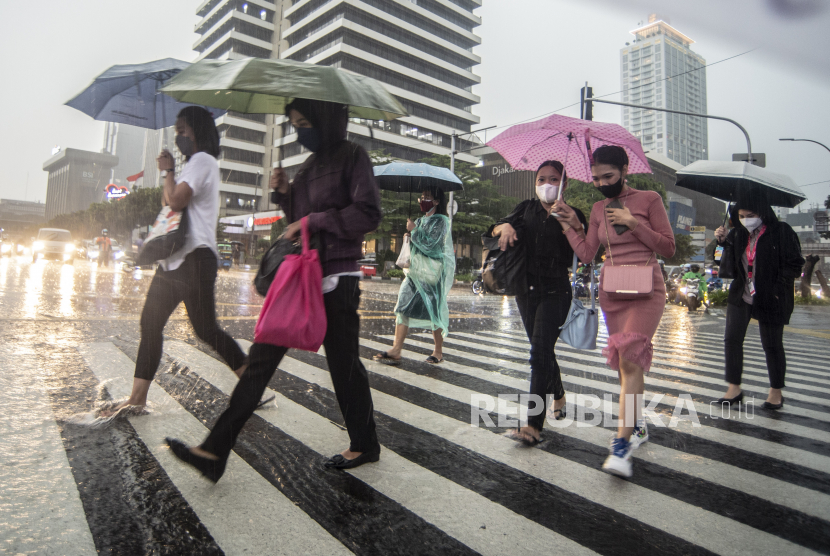 Warga berjalan menggunakan payung di kawasan Sarinah Thamrin, Jakarta. Sejumlah wilayah di Jakarta diprakirakan hujan ringan pada Jumat (8/7/2022) malam.