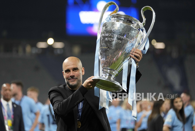 Pelatih Manchester City Josep Guardiola mengangkat trofi Liga Champions. 