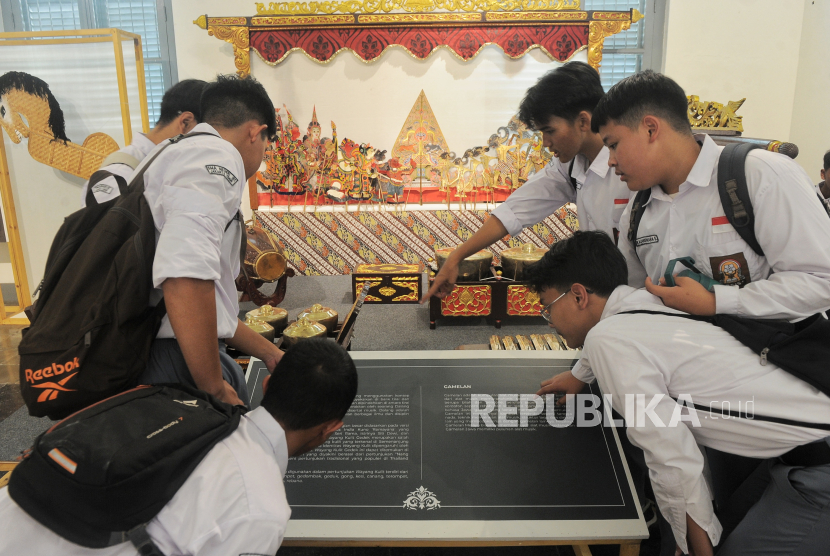 Pengunjung mengamati replika wayang kulit.