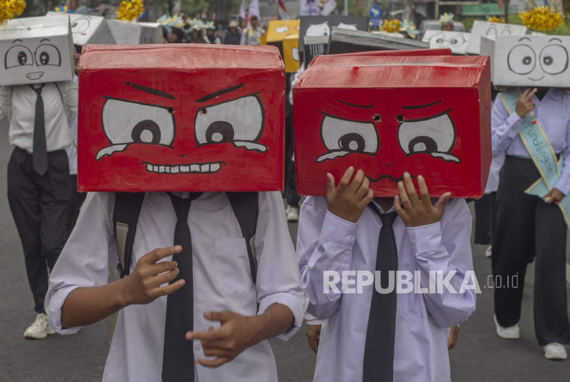 Pelajar menggunakan topeng ekspresi saat mengikuti karnaval Anti Bullying di Salatiga, Jawa Tengah, Sabtu (11/11/2023). Pelaku perundungan masih memiliki hak atas pendidikan.