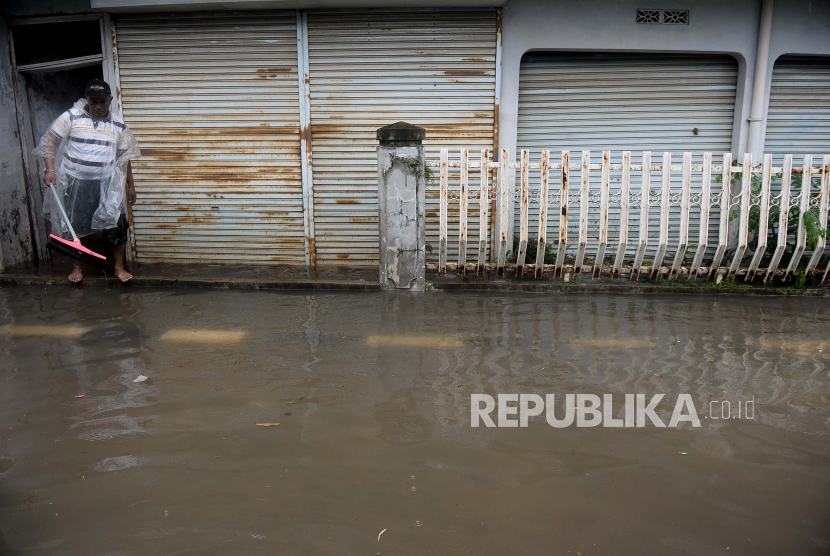 Warga membersihkan genangan banjir di sekitar rumahnya (ilustrasi)