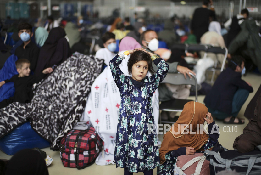 Seorang gadis dari Afghanistan menunggu dengan pengungsi lain untuk terbang ke Amerika Serikat atau lokasi penyelamatan lainnya di gerbang keberangkatan darurat di dalam gantungan di Pangkalan Udara Amerika Serikat di Ramstein, Jerman, Rabu, 1 September 2021. Pemerintah AS mengizinkan pemberian bantuan kemanusiaan untuk warga Afghanistan.