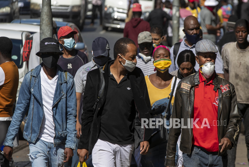 Bepergian di Dalam Semua Negara Afrika Diperbolehkan. Orang-orang yang memakai masker wajah untuk melindungi dari virus corona, berjalan di jalan di pusat kota Johannesburg, Afrika Selatan, Senin, 11 Mei 2020.