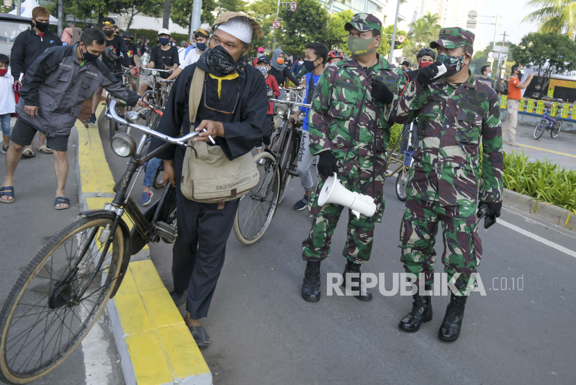 Petugas TNI menghimbau warga untuk menerapkan protokol kesehatan saat berolahraga pada Hari Bebas Kendaraan Bermotor (HBKB) atau Car Free Day (CFD) dimasa Pembatasan Sosial Berskala Besar (PSBB) transisi di kawasan Jalan Sudirman Jakarta. (Ilustrasi)