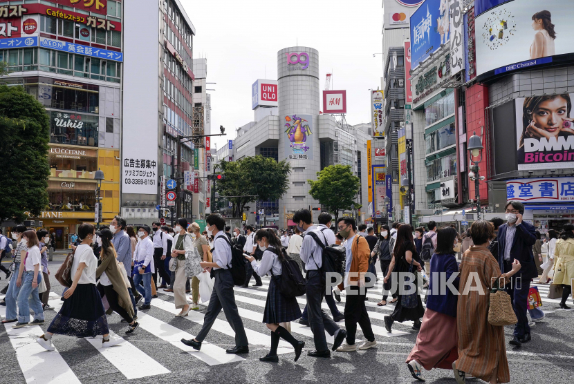 Pejalan kaki berjalan di sepanjang persimpangan Shibuya berebut di Tokyo, Jepang, 28 Mei 2021. 