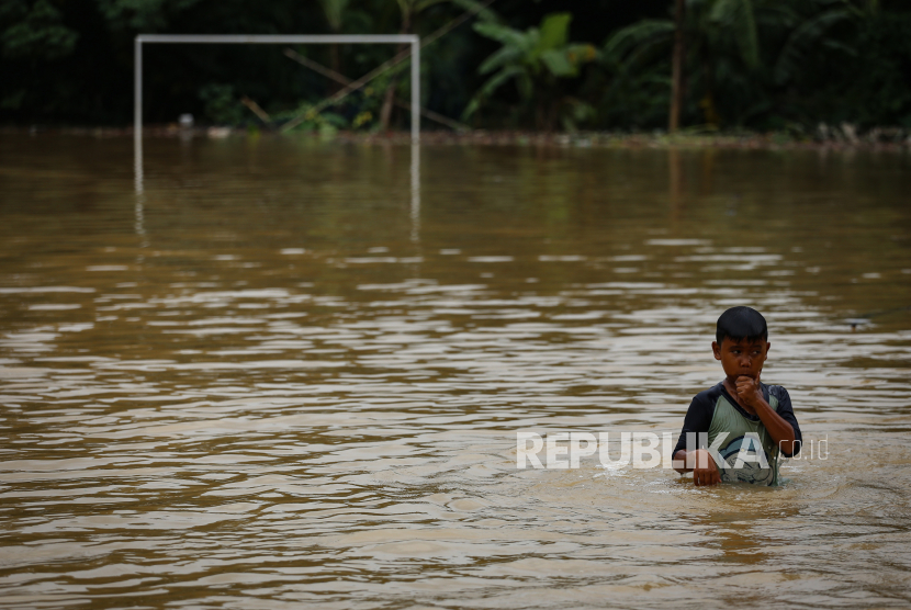 Seorang bocah berada di kawasan banjir (ilustrasi)