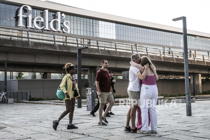 Tiga orang saling berpelukan di depan pusat perbelanjaan Fields di Kopenhagen, Denmark, 03 Juli 2022. Sebuah penembakan terjadi, pada sore hari tanggal 03 Juli, di pusat perbelanjaan Fields di Amager di Orestad Kopenhagen. Polisi Kopenhagen mengkonfirmasi bahwa setidaknya tiga orang telah tewas.