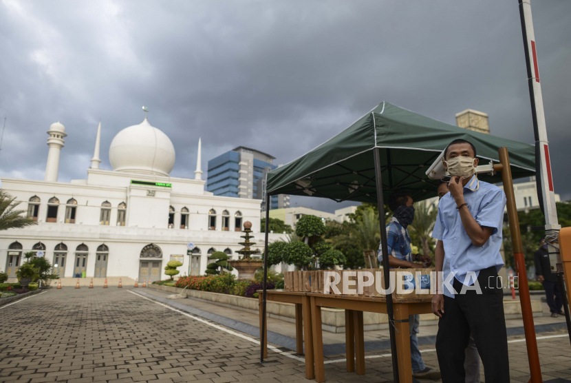 Petugas menunggu warga untuk dibagikan takjil dengan sistem drive thru di Masjid Agung Al-Azhar, Jakarta, Ahad (26/4). Selama Bulan Ramadan, pengurus Masjid Agung Al-Azhar membagikan sebanyak 300 takjil kepada pengendara yang melintas di sekitar lokasi tersebut