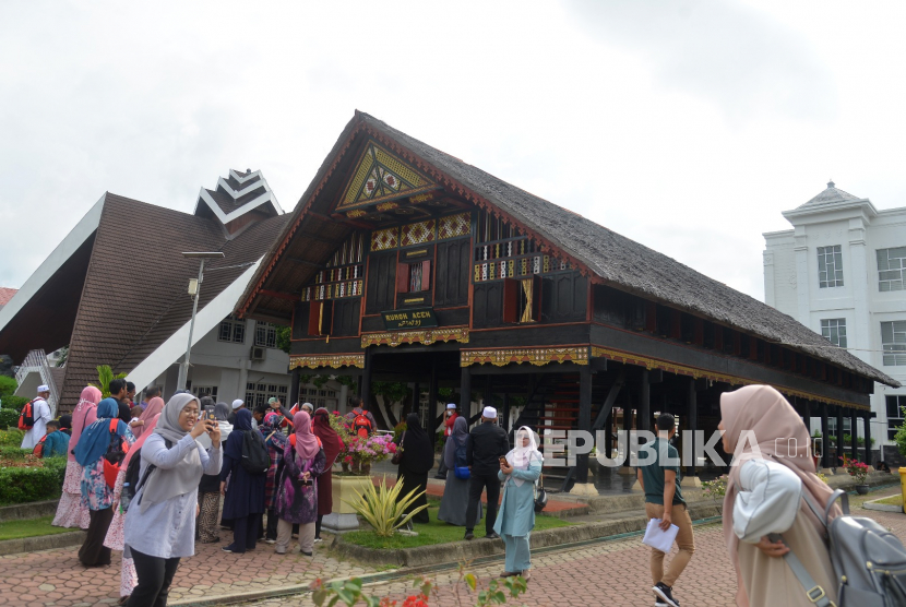 Rombongan wisatawan asal Malaysia mengunjungi Rumah Adat Aceh menjelang penutupan sejumlah objek wisata di Banda Aceh, Aceh, Selasa (17/3/2020). Pemerintah Aceh menutup sejumlah objek wisata bagi pengunjung selama 14 hari terhitung tanggal 17/3/2020 untuk pencegahan virus COVID-19. 